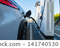 Electric car charging at a outdoor public charging station. Electric car charging at a outdoor public charging station. 141740530