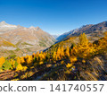 Mountain range above a colorful autumn forest on a clear day. Mountain range above a colorful autumn forest on a clear day. 141740557