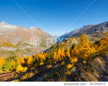 Mountain range above a colorful autumn forest on a clear day. Mountain range above a colorful autumn forest on a clear day. 141740557
