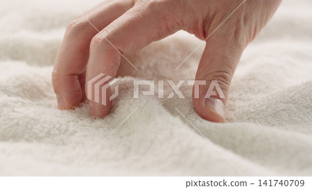 closeup shot of man touching white cotton terry towel closeup shot of man touching white cotton terry towel 141740709