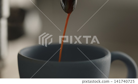 closeup shot of espresso poured into blue cup with professional coffee machine closeup shot of espresso poured into blue cup with professional coffee machine 141740725