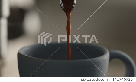 closeup shot of espresso poured into blue cup with professional coffee machine closeup shot of espresso poured into blue cup with professional coffee machine 141740726
