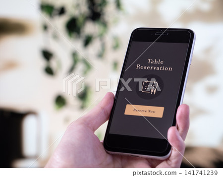 A smartphone photo showing an online reservation app for restaurants and eateries (the screen design was originally created). A smartphone photo showing an online reservation app for restaurants and eateries (the screen design was originally created). 141741239