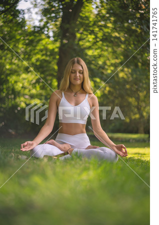 Woman in Lotus Pose With Hands in Mudra in a Park Woman in Lotus Pose With Hands in Mudra in a Park 141741765