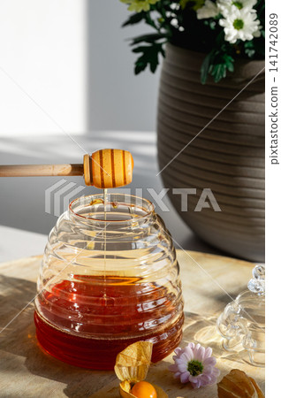 Drizzling Honey into a Beehive Jar by Flowers Drizzling Honey into a Beehive Jar by Flowers 141742089
