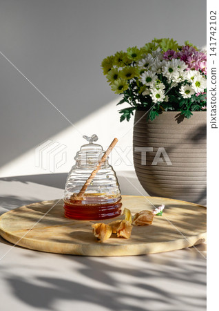 Beehive Honey Jar and Dipper in Sunlight Beehive Honey Jar and Dipper in Sunlight 141742102