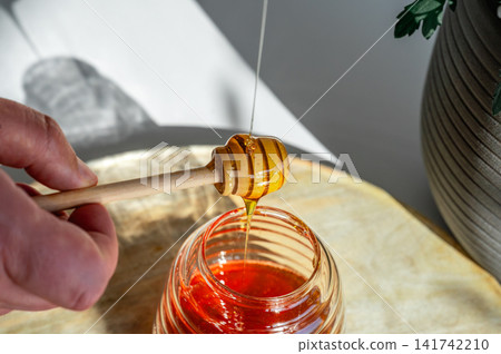 Honey Dripping from a Dipper into an Open Jar Honey Dripping from a Dipper into an Open Jar 141742210