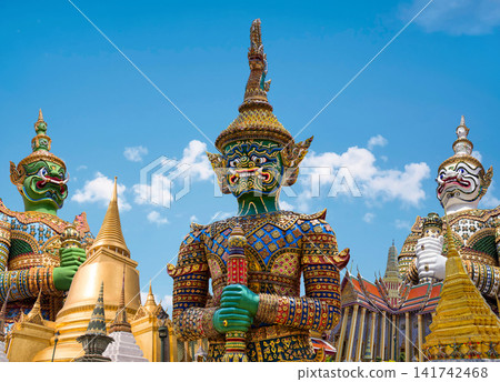 Colorful giant guardian statue with iconic temples and Grand Palace in Bangkok, Thailand. Colorful giant guardian statue with iconic temples and Grand Palace in Bangkok, Thailand. 141742468
