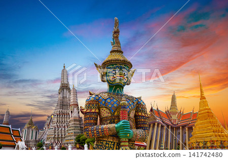 Colorful giant guardian statue with iconic temples and Grand Palace in Bangkok, Thailand. Colorful giant guardian statue with iconic temples and Grand Palace in Bangkok, Thailand. 141742480