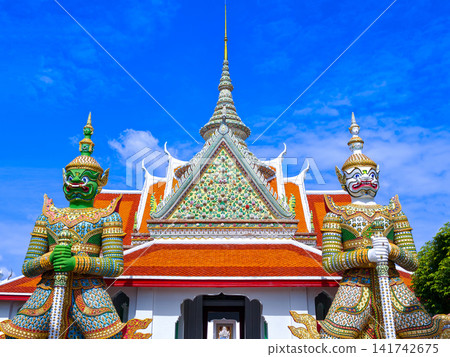 Colorful giant guardian statue at Wat Phra Kaew with traditional Thai temple architecture in Bangkok. Colorful giant guardian statue at Wat Phra Kaew with traditional Thai temple architecture in Bangkok. 141742675