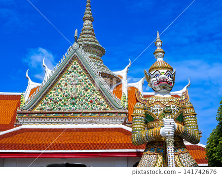 Colorful giant guardian statue at Wat Phra Kaew with traditional Thai temple architecture in Bangkok. Colorful giant guardian statue at Wat Phra Kaew with traditional Thai temple architecture in Bangkok. 141742676