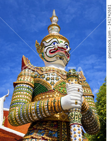 Colorful giant guardian statue at Wat Phra Kaew with traditional Thai temple architecture in Bangkok. 141742681