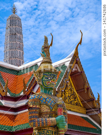 Colorful giant guardian statue at Wat Phra Kaew with traditional Thai temple architecture in Bangkok. Colorful giant guardian statue at Wat Phra Kaew with traditional Thai temple architecture in Bangkok. 141742686