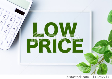 A whiteboard with the words "LOW PRICE" and a white calculator. A whiteboard with the words "LOW PRICE" and a white calculator. 141742717