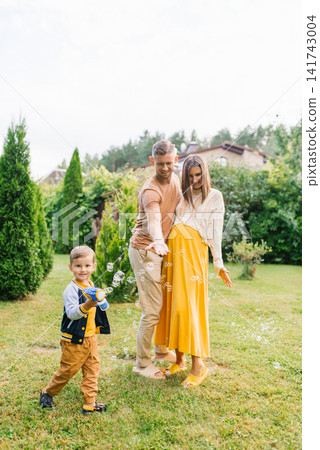 Family With Pregnant Mother Playing With Bubbles Family With Pregnant Mother Playing With Bubbles 141743004