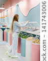 Customer Choosing Sweets in Colorful Candy Shop 141743006