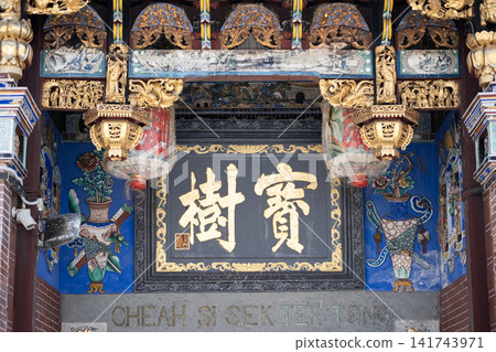 Ornate entrance of a traditional temple featuring intricate carvings, colorful lanterns, and decorative elements, showcasing cultural heritage and architectural beauty Ornate entrance of a traditional temple featuring intricate carvings, colorful lanterns, and decorative elements, showcasing cultural heritage and architectural beauty 141743971
