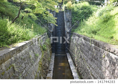 Stone waterways remain in the lush green park. Stone waterways remain in the lush green park. 141744283