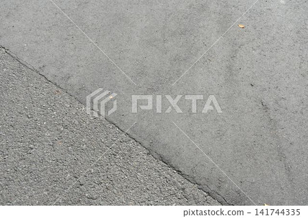 Sunlight filtering through the trees and small fallen leaves onto the asphalt road. Sunlight filtering through the trees and small fallen leaves onto the asphalt road. 141744335