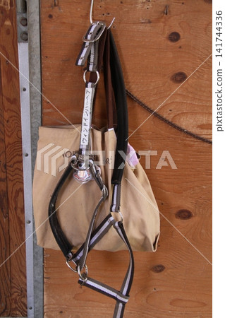 A horse training tack called a "making holder" hanging in the stable. A horse training tack called a "making holder" hanging in the stable. 141744336