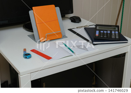 Schoolboy workspace setup with math stationery on white desk. Notebook, pencil, rulers, calculator. Primary School Geometry. Mathematics Homework study. Back to School Preparation. Analytical Thinking Schoolboy workspace setup with math stationery on white desk. Notebook, pencil, rulers, calculator. Primary School Geometry. Mathematics Homework study. Back to School Preparation. Analytical Thinking 141746029