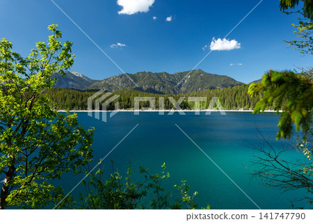 Travel landscape of Eibsee lake and mountain peak in Alps in Bavaria, Germany, scenic summer nature panorama with forest und mountains. Alpine landscape Travel landscape of Eibsee lake and mountain peak in Alps in Bavaria, Germany, scenic summer nature panorama with forest und mountains. Alpine landscape 141747790