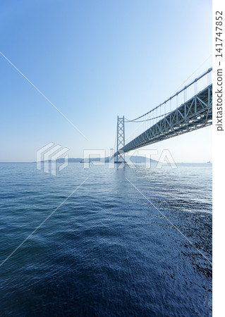 明石海峽大橋是世界上最大的懸索橋之一,橫跨瀨戶內海,映襯著夏日的藍天。 明石海峽大橋是世界上最大的懸索橋之一,橫跨瀨戶內海,映襯著夏日的藍天。 141747852