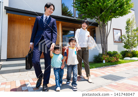 一家四口帶著笑容離開家(父親通勤去上班,孩子們去托兒所/學校)。 一家四口帶著笑容離開家(父親通勤去上班,孩子們去托兒所/學校)。 141748047