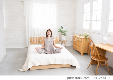 中年婦女在床上伸展身體 中年婦女在床上伸展身體 141748108