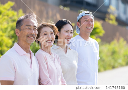 A senior couple and a young couple standing side by side, both smiling. A senior couple and a young couple standing side by side, both smiling. 141748160