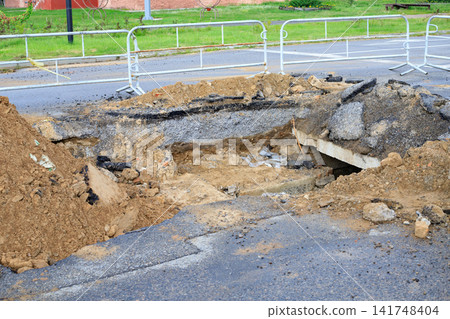 Dug Up Asphalt Road with Metal Safety Fences During Underground Heating Network Repair 141748404