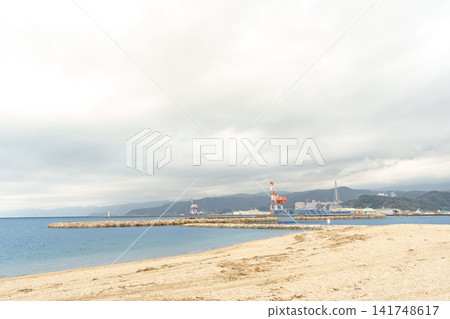 A beautiful view of Tsuruga Bay's sandy beach and the harbor towering in the distance, seen from the coast of Kehi no Matsubara. A beautiful view of Tsuruga Bay's sandy beach and the harbor towering in the distance, seen from the coast of Kehi no Matsubara. 141748617