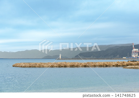 A beautiful view of Tsuruga Bay's sandy beach and the harbor towering in the distance, seen from the coast of Kehi no Matsubara. A beautiful view of Tsuruga Bay's sandy beach and the harbor towering in the distance, seen from the coast of Kehi no Matsubara. 141748625