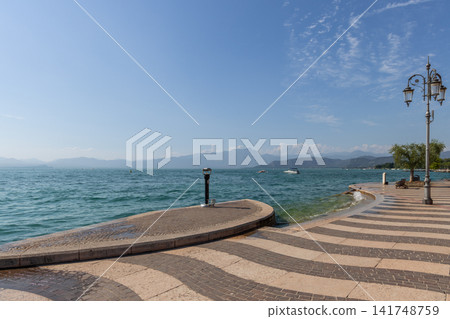 Lungolago Marconi beside Lake Garda in Lazise with patterned paving and ornate lamps 141748759