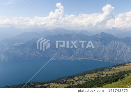 Lake Garda and rugged opposite shore seen from a high Monte Baldo meadow Lake Garda and rugged opposite shore seen from a high Monte Baldo meadow 141748775