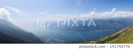 Monte Baldo view across an ultra-wide Lake Garda panorama in soft summer haze Monte Baldo view across an ultra-wide Lake Garda panorama in soft summer haze 141748776