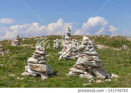 Stone cairns grouped on a wide open mountain meadow on Monte Baldo, Italy Stone cairns grouped on a wide open mountain meadow on Monte Baldo, Italy 141748783
