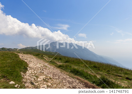Mountain track crossing an exposed grassy ridge on Monte Baldo in Italy Mountain track crossing an exposed grassy ridge on Monte Baldo in Italy 141748791