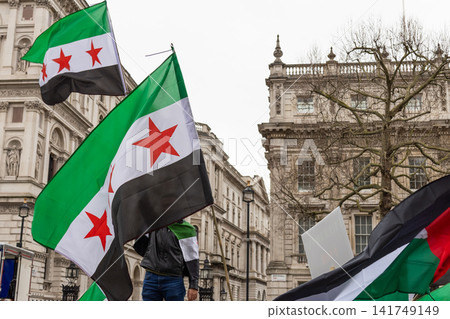 Syrian opposition flags waved during street protest demonstration Syrian opposition flags waved during street protest demonstration 141749149
