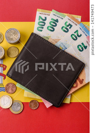 Spain, Spanish euro cash and cent coins against the background of the flag. Euro cash Spain, Spanish euro cash and cent coins against the background of the flag. Euro cash 141749473