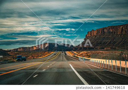 猶他州荒野的壯麗景色,道路綿延至地平線,高聳的懸崖聳立(美國西部)。 猶他州荒野的壯麗景色,道路綿延至地平線,高聳的懸崖聳立(美國西部)。 141749618
