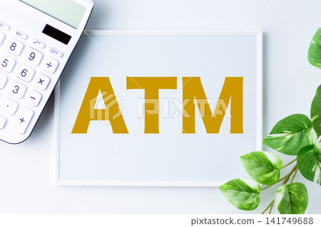 一塊寫著「ATM」字樣的白板和一台白色計算器 一塊寫著「ATM」字樣的白板和一台白色計算器 141749688