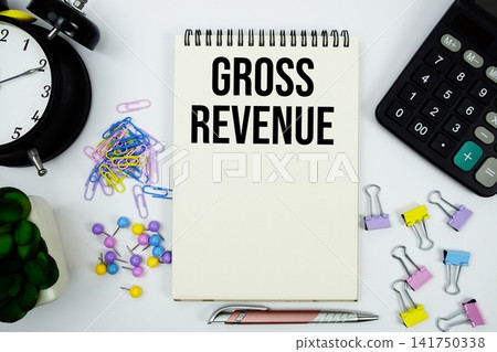 Gross Revenue text written on notepad with calculator and alarm clock Gross Revenue text written on notepad with calculator and alarm clock 141750338
