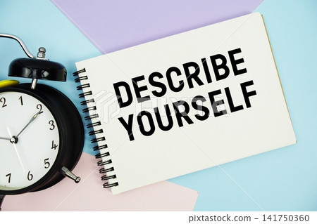 Describe Yourself text written on notepad with alarm clock flat lay on multicolor pastel background Describe Yourself text written on notepad with alarm clock flat lay on multicolor pastel background 141750360