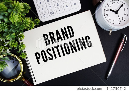 Brand Positioning text written on notepad with alarm clock, magnifying glass and calculator on black background Brand Positioning text written on notepad with alarm clock, magnifying glass and calculator on black background 141750742