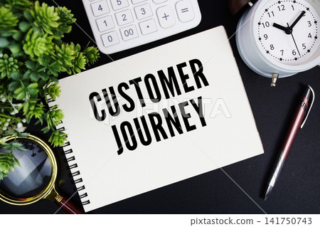 Customer Journey text written on notepad with alarm clock, magnifying glass and calculator on black background Customer Journey text written on notepad with alarm clock, magnifying glass and calculator on black background 141750743