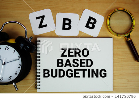 Zero Based Budgeting text written on notepad with magnifying glass and alarm clock on wooden background Zero Based Budgeting text written on notepad with magnifying glass and alarm clock on wooden background 141750796