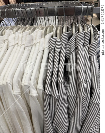 Stacked striped and plain tablecloths on wire shelf, ideal for home decor and retail use Stacked striped and plain tablecloths on wire shelf, ideal for home decor and retail use 141751072