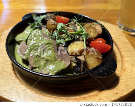 Savory dish with sliced meat, potatoes, mushrooms, cherry tomatoes on wooden table background 141751098