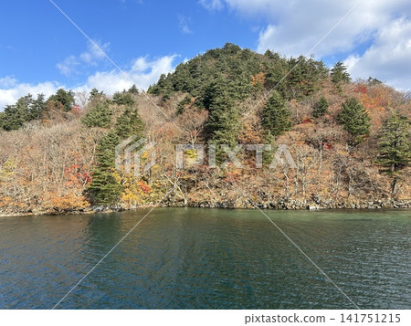 這是從青森縣十和田市十和田湖上的觀光船上看到的陸地小山丘上的秋葉景色。 這是從青森縣十和田市十和田湖上的觀光船上看到的陸地小山丘上的秋葉景色。 141751215